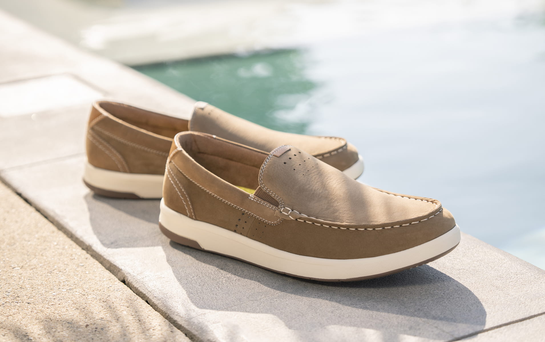 Florsheim casual category featuring the Crossover Moc Toe Slip On Sneaker by a pool.