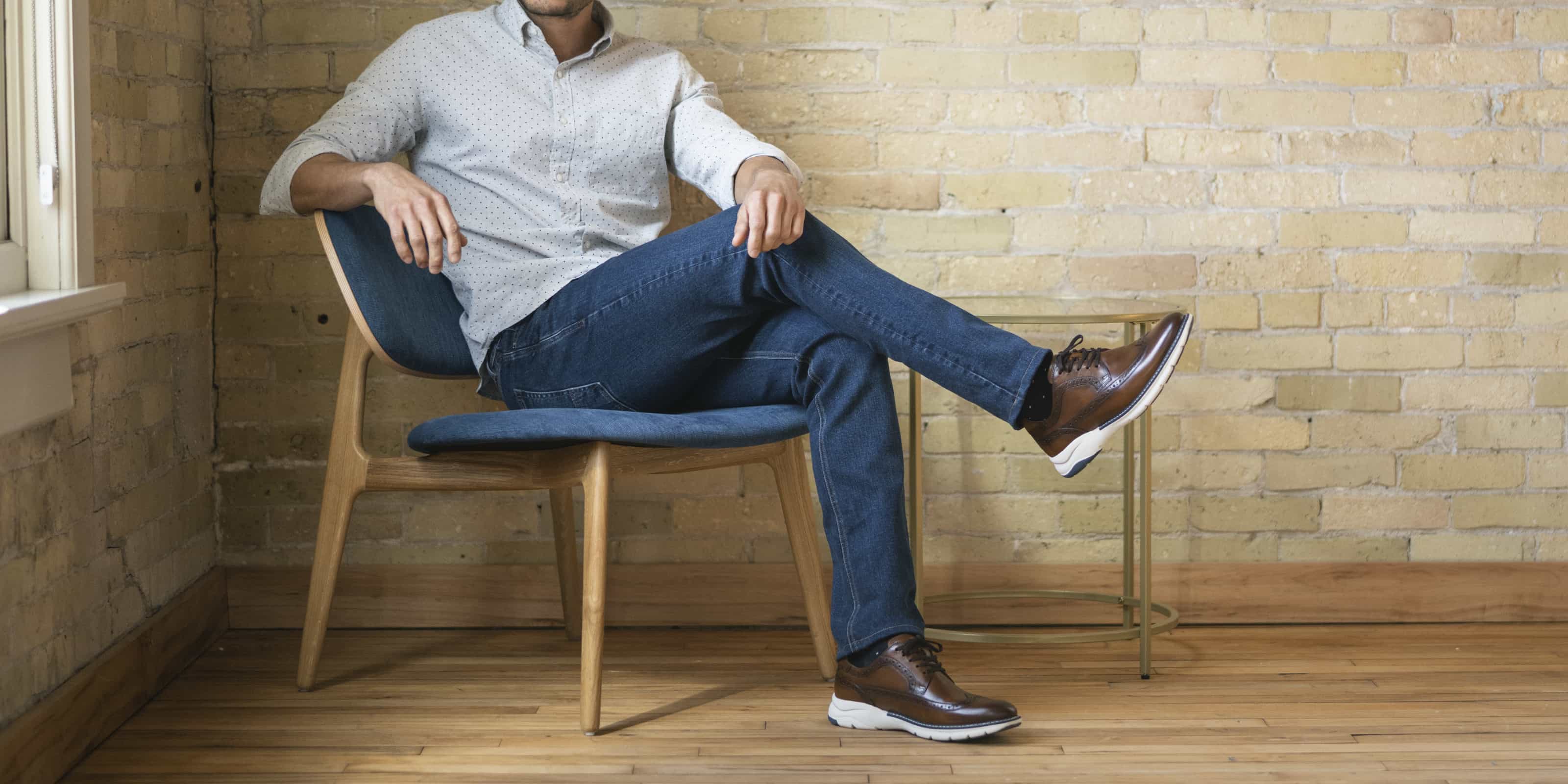 The featured image is a man sitting in a chair wearing the Frenzi Wingtip Oxford in Cognac. 