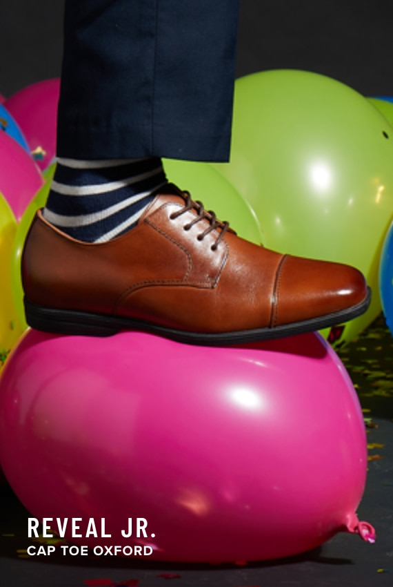 Kids Shoes view all category. Image features the Reveal Jr Cap Toe Oxford in Cognac.
