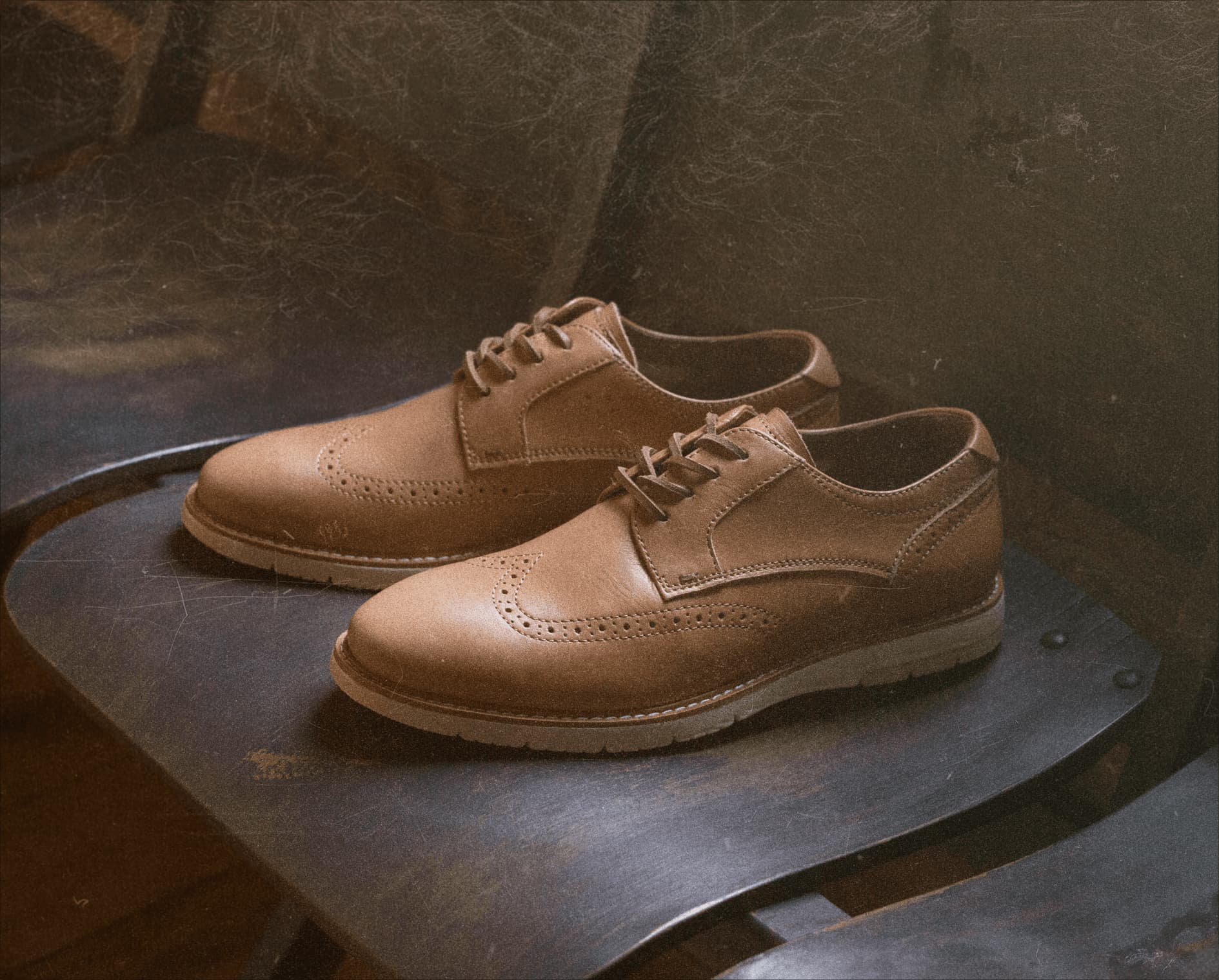 Image features the Vibe Lux Wingtip in veg tan on a wood chair.
