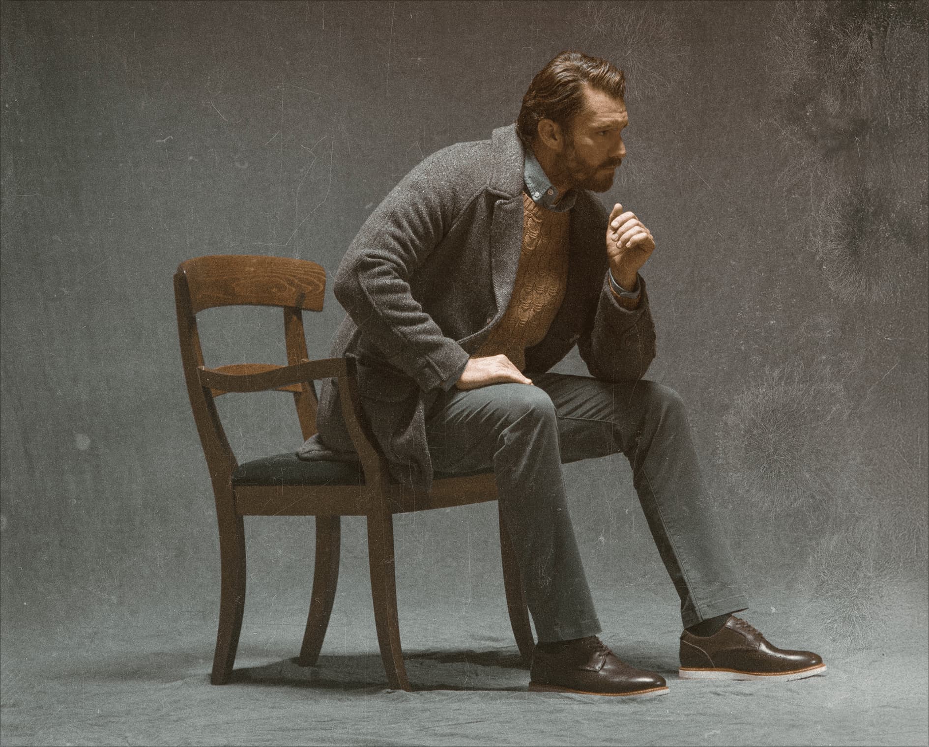 Image features a man on a wood chair wearing the Vibe Lux Wingtip in brown.