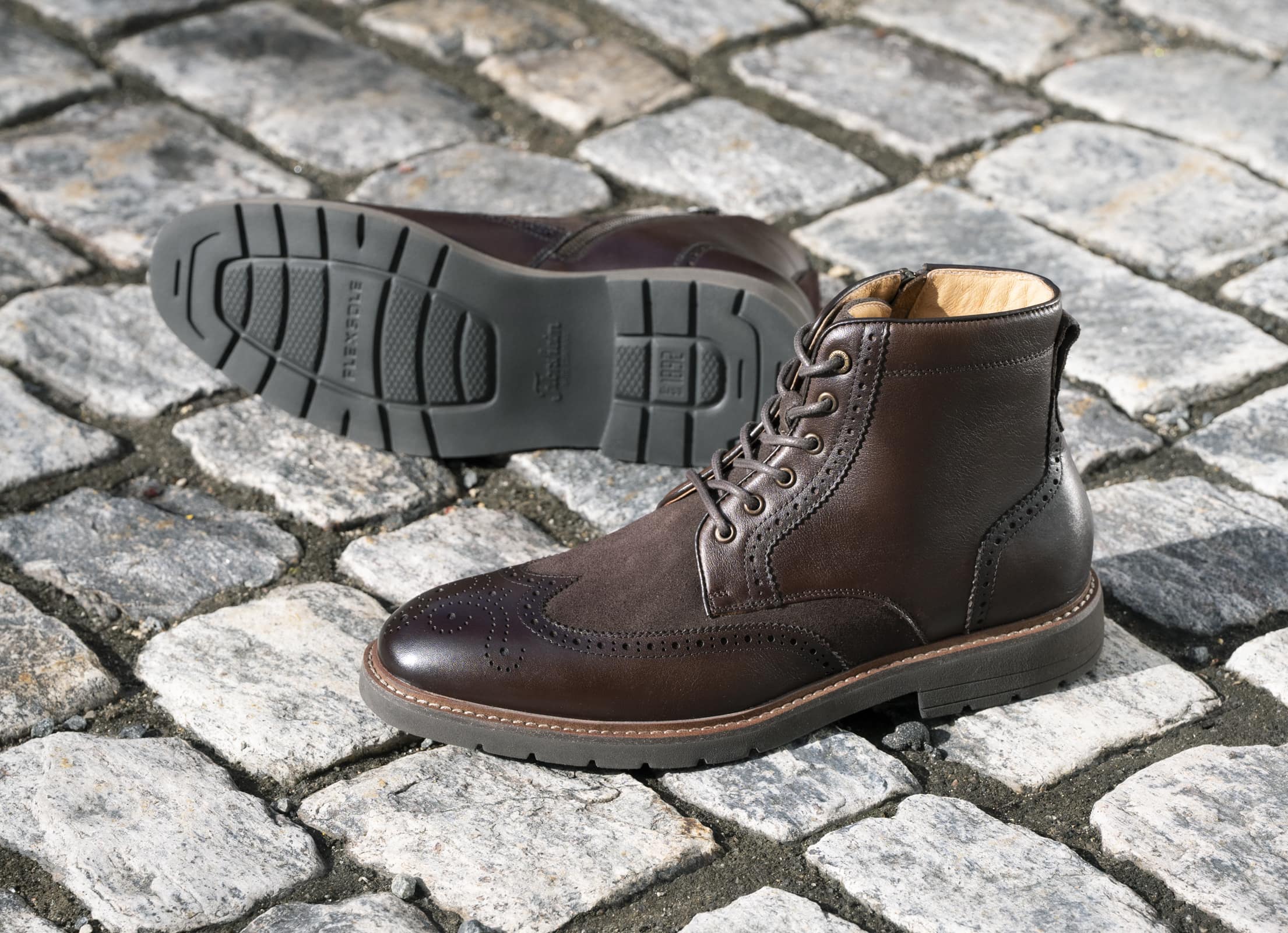 Shop the Florsheim Men's New Arrivals featuring the Redford Wingtip Boot in Brown on a cobblestone backdrop.