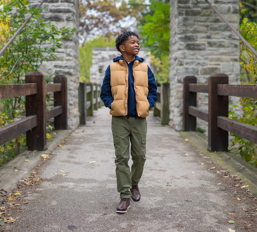 Shop Florsheim kids featuring a kid walking down the street in the Vibe Jr. Elastic Lace Plain Toe Chukka Boot.