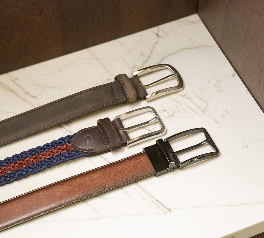 Shop Florsheim belts featuring a variety of styles on a marble slab. 