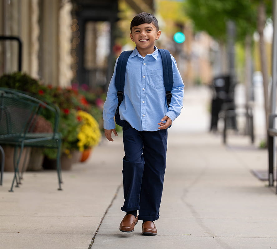 Shop Florsheim Kids featuring a kid walking down the street in cognac loafers. 