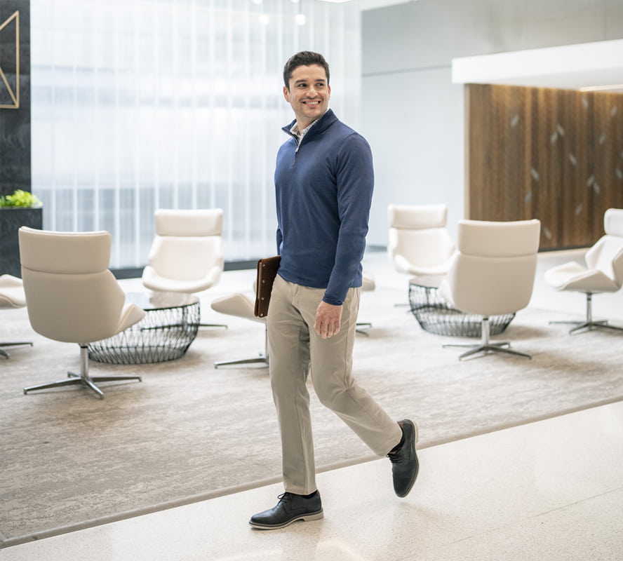 Shop Florsheim career ready styles featuring a man walking through a common area in the Norwalk oxford in black.