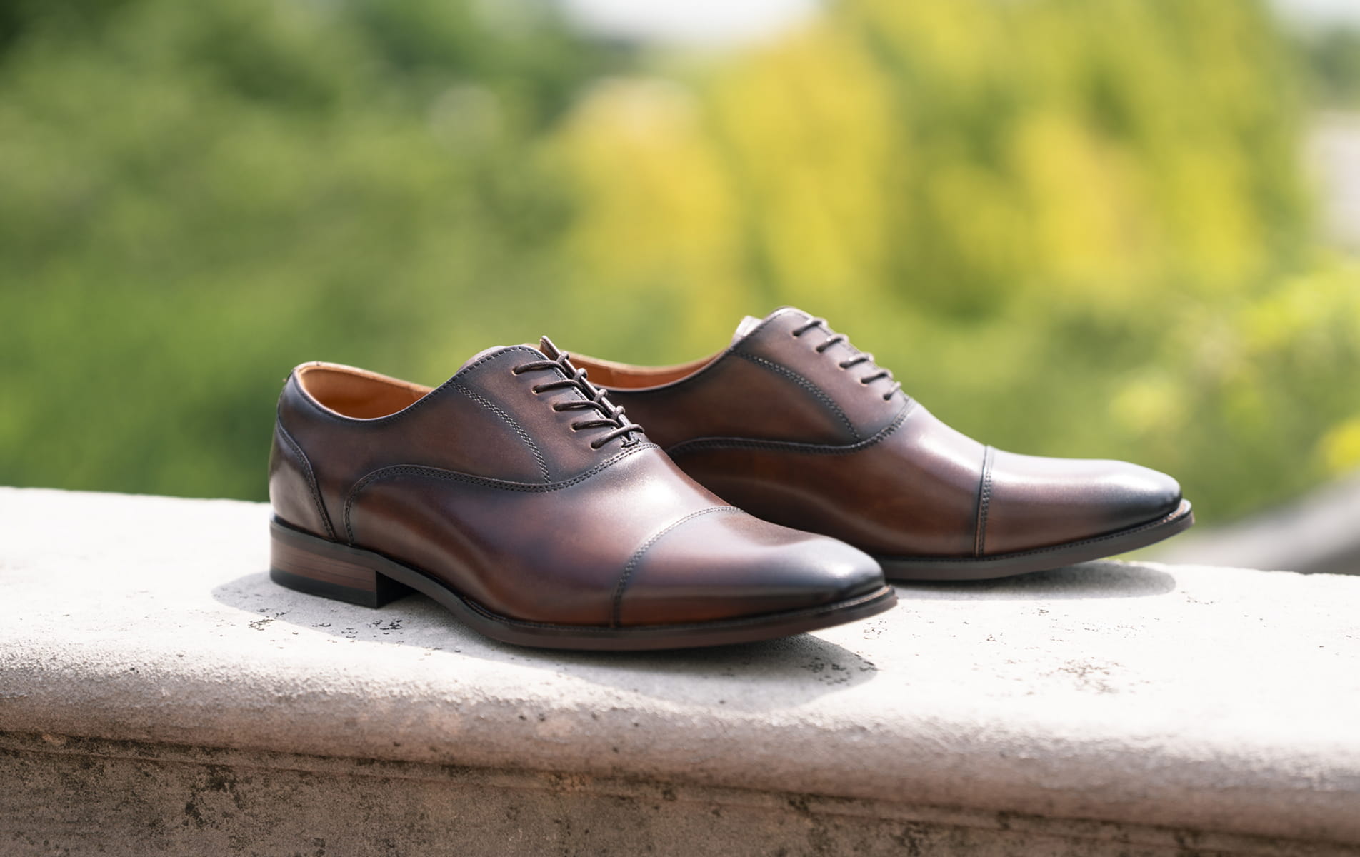 Shop Florsheim dress featuring the Sorrento Lux in brown on a outdoor ledge.