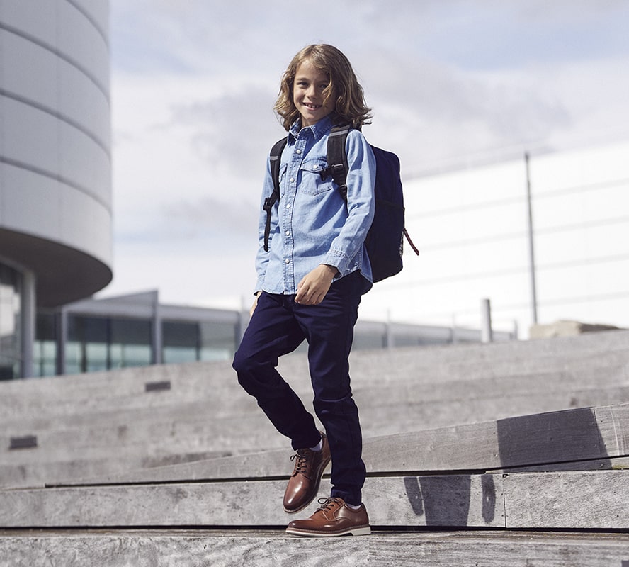 Shop Florsheim Kids featuring the Norwalk Jr. in cognac on a kid walking down steps.