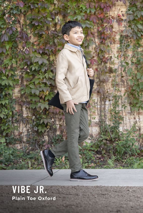 Kids Shoes view all category. Image features the Vibe Jr. oxford in black.