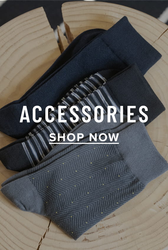 Men's Accessories view all category. Image features a variety of socks on a wood surface.