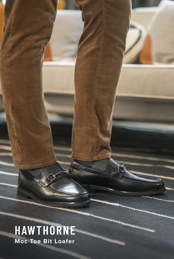 Men's Dress Shoes category. Image features the Hawthorne Moc Toe Bit Loafer in Black on striped carpet.