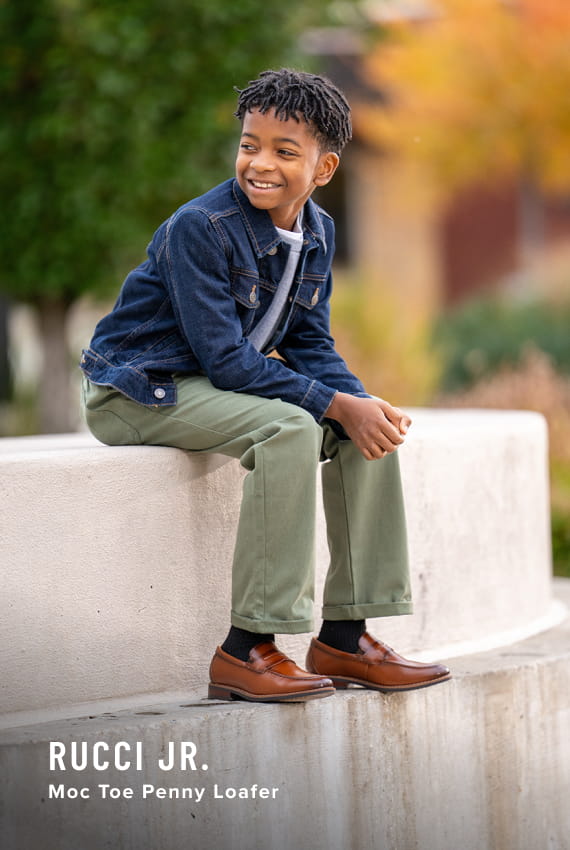 Kids Shoes view all category. Image features the Rucci Jr. penny loafer in cognac.
