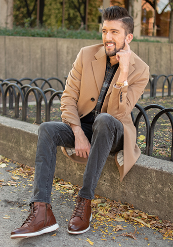 Image of social media influencer Thomas Trust sitting outside wearing the Flair Moc Toe Lace Up Boot in Cognac.