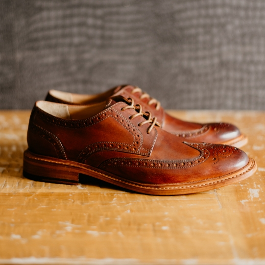 "Goodyear Welt: Why It's Worth The Investment." The featured product is Kenmoor Wingtip Oxford in Cognac.