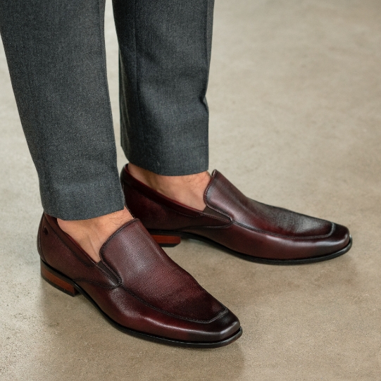 "Do You Wear Socks With Loafers? Our Guide Will Help You Decide." The featured image is a model wearing the Postino Moc Toe Venetian Slip On in Burgundy.