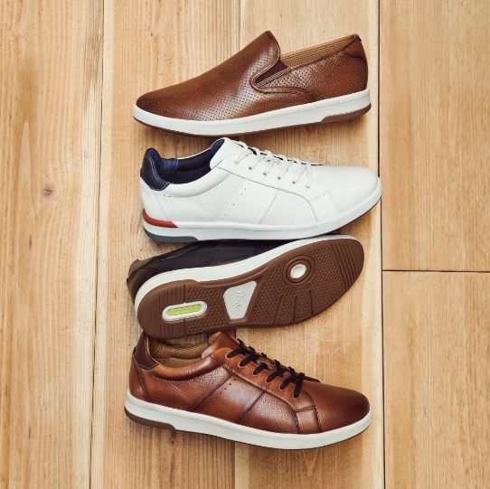 "Sizing Shoes At Home Is Easy With Our Helpful Tips." The featured products are the Premier Plain Toe Slip On in Cognac, Crossover Lace To Toe Sneaker in White, Crossover Lace To Toe Sneaker in Black, and Crossover Lace To Toe Sneaker in cognac.