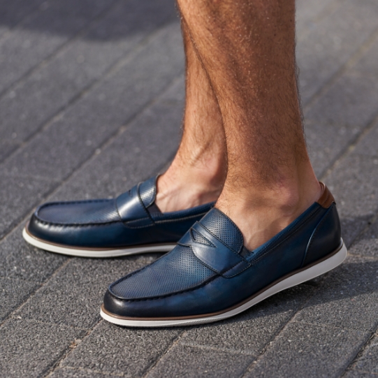 "How The Penny Loafer Got Its Name." The featured product is the Atlantic Moc Toe Penny Loafer in Navy.