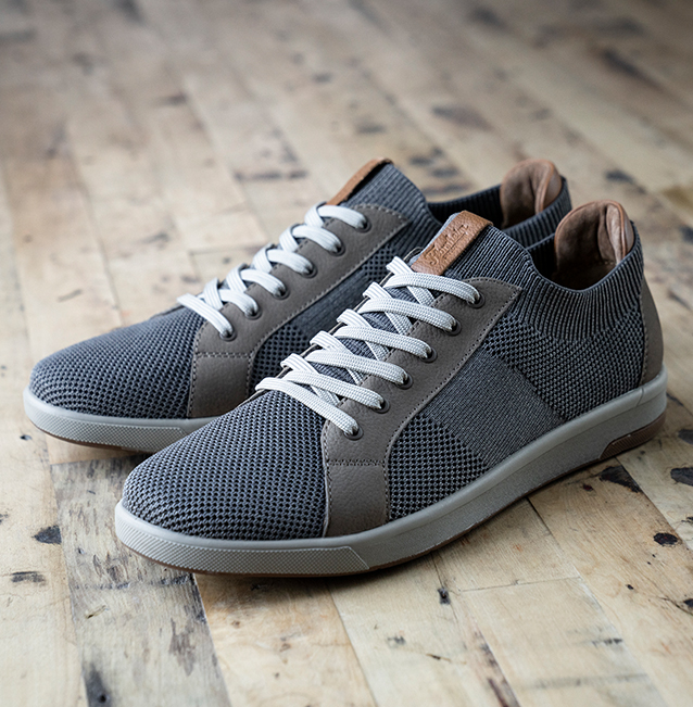 "Men's Travel Tips, The Right Shoes For The Road." The featured product is the Crossover Knit Lace To Toe Sneaker in Stone. 