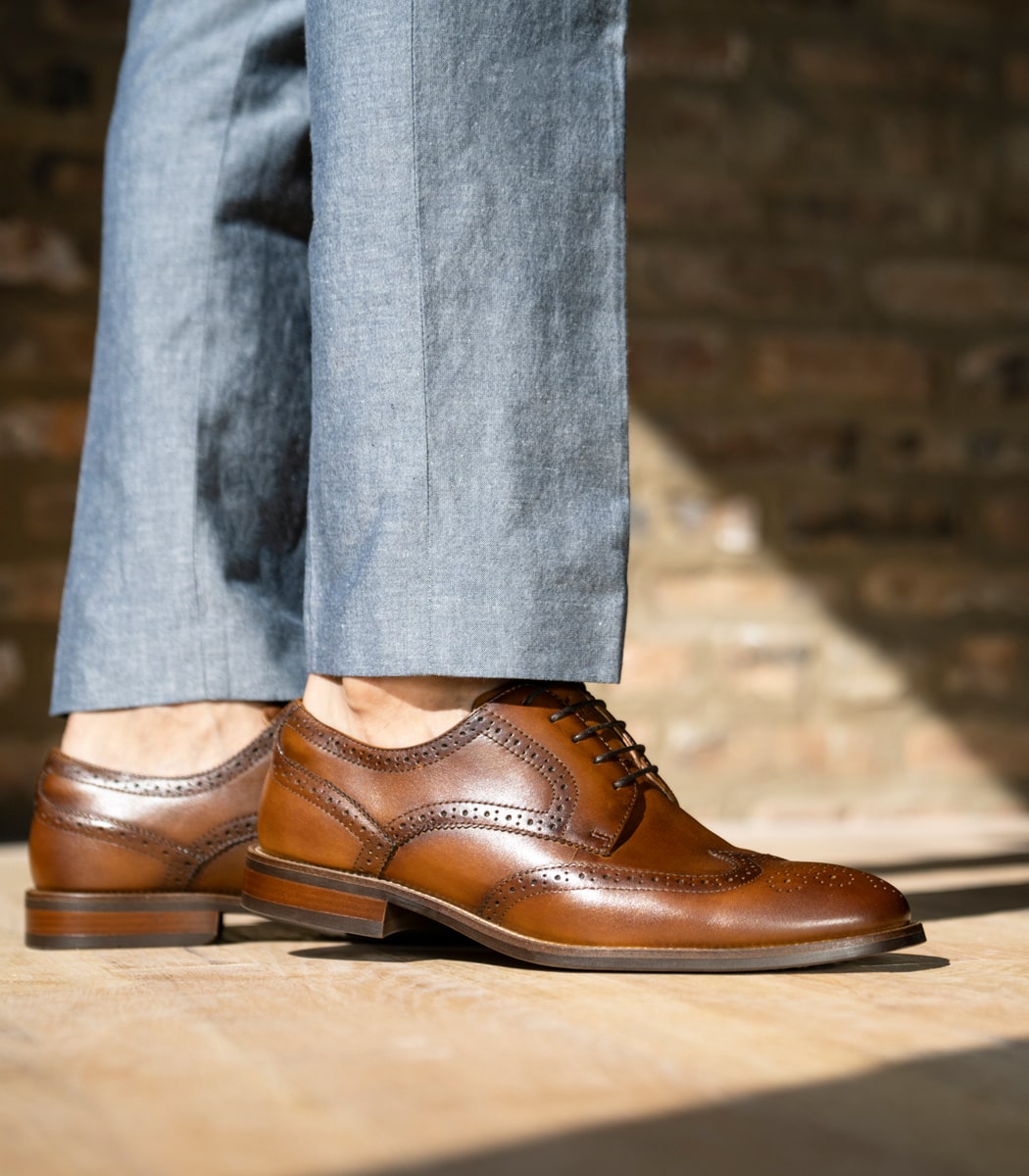 The featured image is a model wearing the Rucci Wingtip Oxford in Cognac. 
