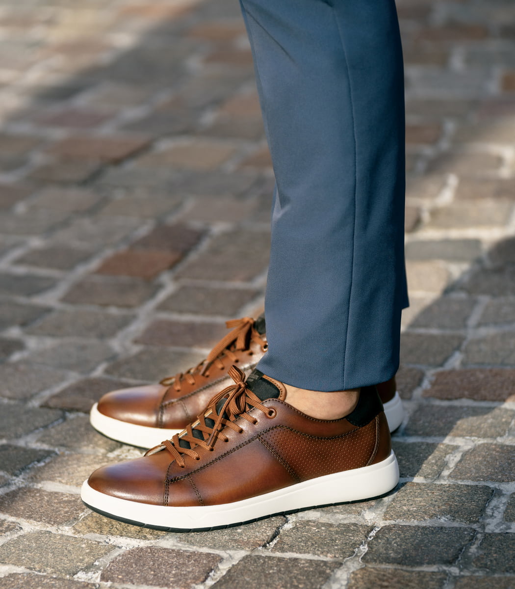 The featured product is the Heist Lace to Toe Sneaker in Cognac.