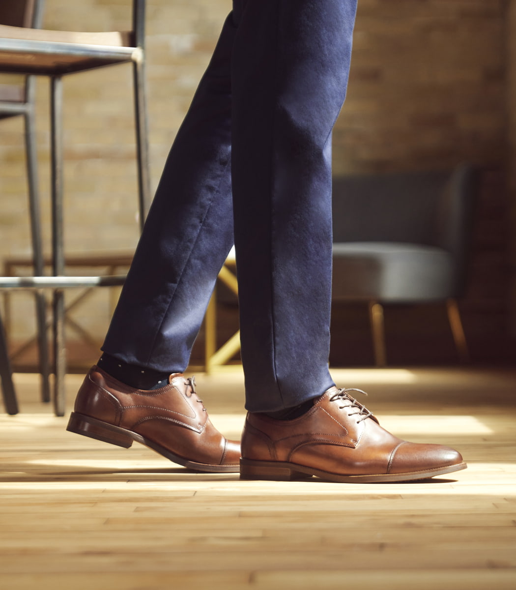 The featured product is the Rucci Cap Toe Oxford in Cognac.