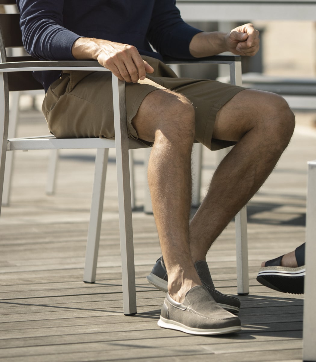 The featured image is a man sitting in a chair wearing the Montigo Canvas Moe Toe Venetian Loafer in Gray.