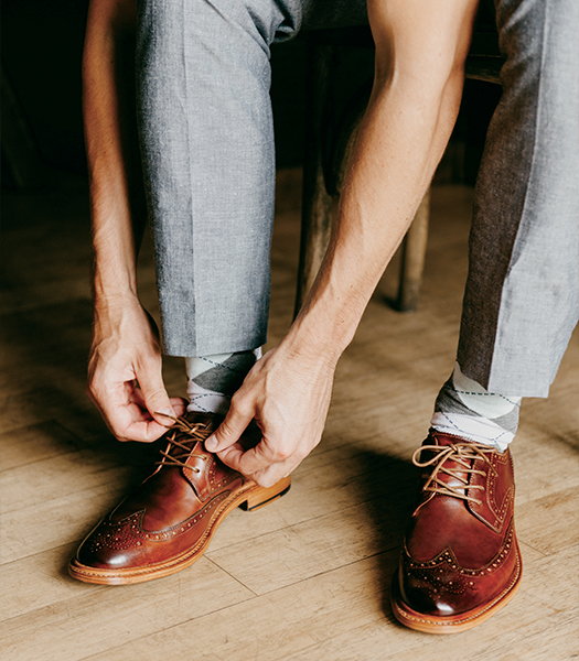 The featured image is a man tying the shoe laces of the Mercantile Wingtip Oxford.