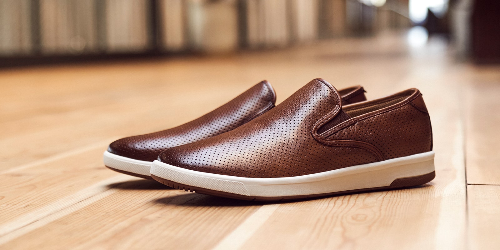 The featured image is a pair of Crossover Plain Toe Slip On Sneakers on parquet floor.