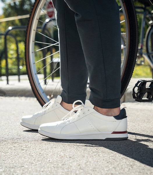 The featured image is a pair of Crossover Lace To Toe Sneakers in White in front of a bicycle wheel.