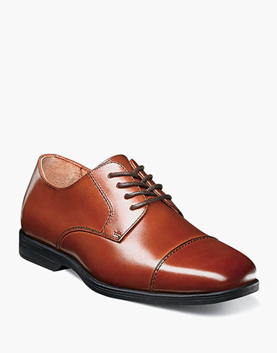 The featured product is the Reveal Jr. Cap Toe Oxford in Cognac.